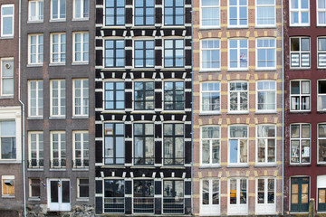 Fototapeta na wymiar Typical houses on Damrak street in Amsterdam, Holland, Netherlands