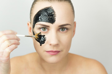 Obraz premium Woman with purifying black mask on her face 