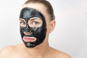 Woman with purifying black mask on her face
