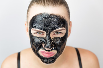 Woman with purifying black mask on her face
