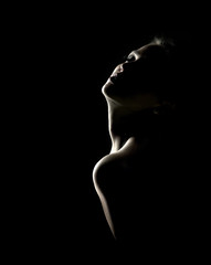 Obraz premium Sensual portrait of woman in shadow on dark background