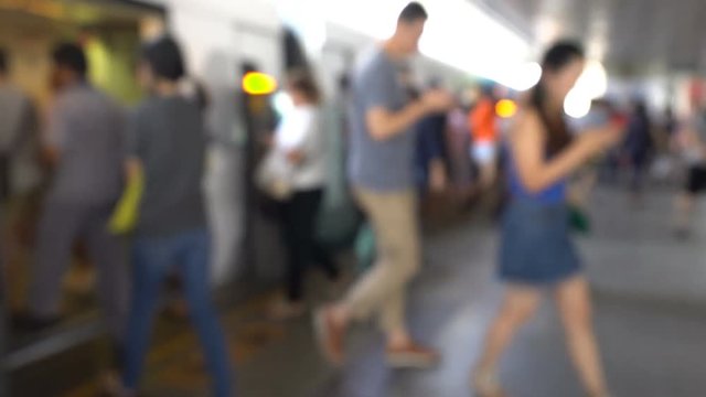 The blurred with many people getting out of skytrain at station