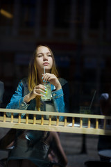 Nice girl behind glass of cafe.