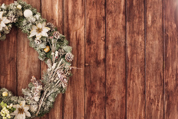 beautiful green christmas wreath with white flowers hang on Wood