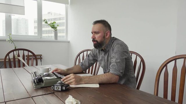 Male writer looking for inspiration and typiing on the typewriter