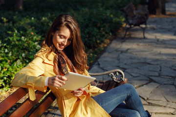 Young woman using digital tablet in the park