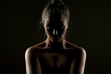 Fototapeta na wymiar Misterious portrait of woman in shadow on dark background