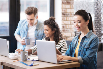 Smiling girl working on the laptop