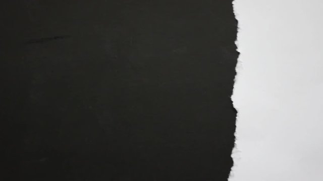Close up of paper tearing into hole black screen background