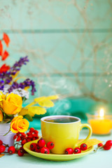 Cup of coffee, autumn leaves and flowers on a wooden table. Autumn still life. Selective focus.