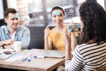 Curly-haired girl taking photos of her friends