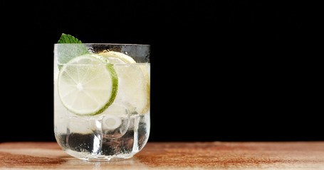 closeup of coctail. Mojito, tonik water with mint and lemon and lime and ice cubes closeup buubles ice texture