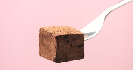 truffle sweet on fork with a powder cover in pink background