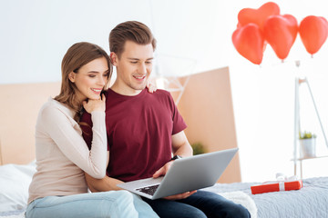 Charming couple using laptop together