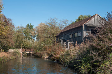 Fototapeta na wymiar moulin à eau ancien au bord d'une rivière