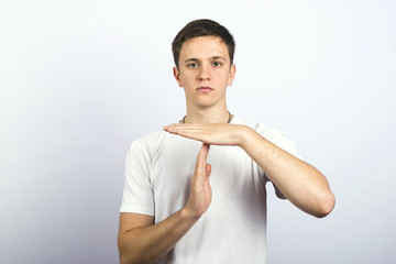 Portrait of a young guy showing a timeout