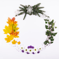 Wreath made of natural material, symbolizing the seasons of the year, on a white background. Top view.