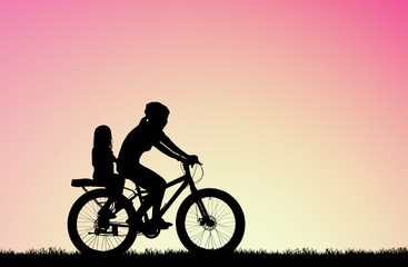 silhouette Mother ride a bike with daughter  on blurry sunrise