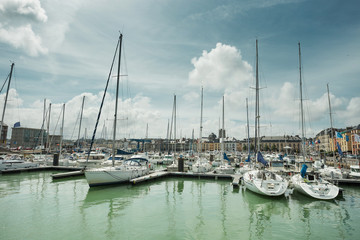 Yachts moored at quay port of Dieppe, France. Concepts of success, leisure, holiday, rich, tourism, luxury, lifestyle. Sunny Summer, blue sky. Toned