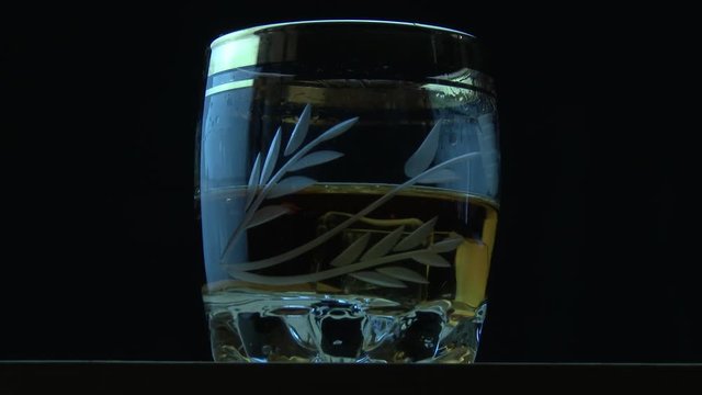 Ice cubes fall into cognac