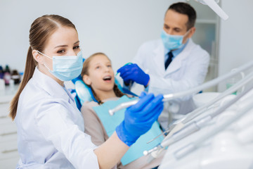 Pleasant female doctor taking her equipment