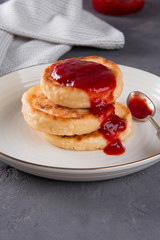 Syrniki with strawberry jam.