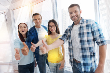 Obraz premium Happy young people raising their thumbs