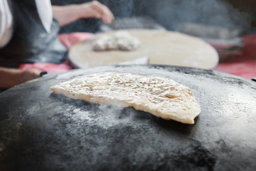 Granny chef cook Turkish pancake Gozleme on the stove