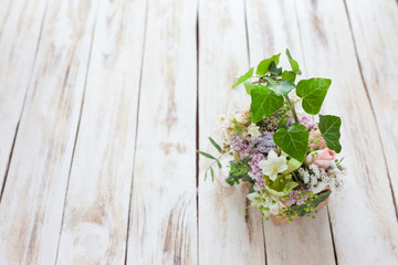 Bouquet of flowers on a old light shabby chic wooden background. Place for text.