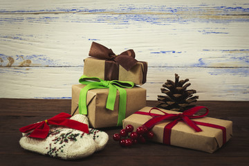 Gift boxes, knitted socks, a red bow, a cone, a branch of a viburnum