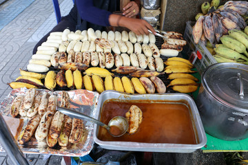 Local seller make Roasted Pisang Awak banana and  musa silver bluggoe banana at Saphan Khwai, Bangkok, Thailand