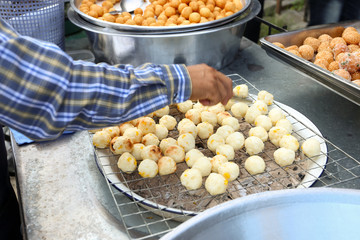 Local seller make Thai roasted sweet potato ball,  Khanom Man Tip, Bangkok, Thailand