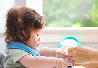 Happy little baby boy being fed by his mother