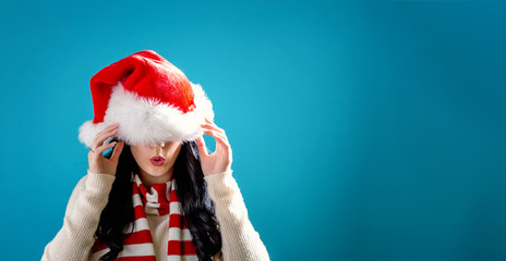Woman with a Santa hat pulled over her eyes