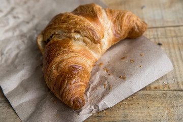 Fresh croissant lies on paper