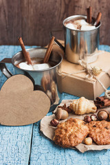 Metal cups with cacao and marshmallow and different cookies