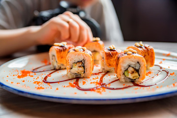 Food photographer takes picure of sushi rolls