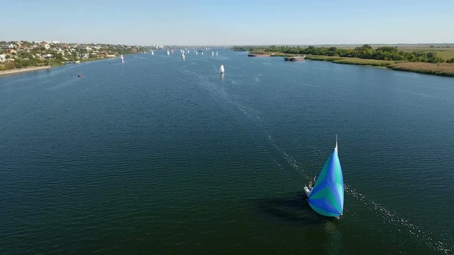 A wonderful bird`s eye shot of a blue yacht floating in the Dnipro river on a sunny day in summer. The riverscape is great and gorgeous with its shining blue waters.