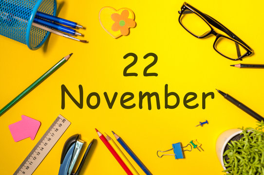 November 22nd. Day 22 of last autumn month, calendar on yellow background with office supplies. Business theme