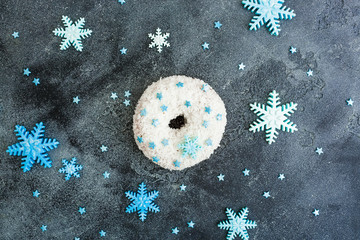 Christmas or New Year food concept with donut and edible sugary snowflakes on dark background....