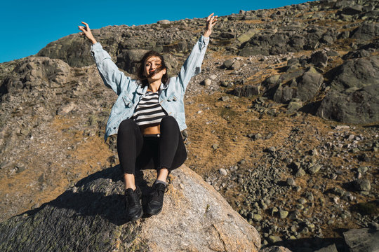 Woman sitting on stone in a rocky slope