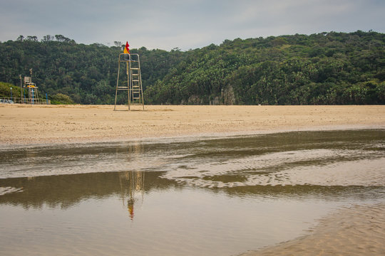 Lifeguard's chair reflected in a pool on a beach in the Eastern Cape, South Africa
