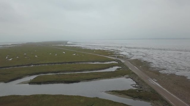 Aerial of Low tide path to the island Mand&oslash; in Denmark, only access by car &ndash; 4K