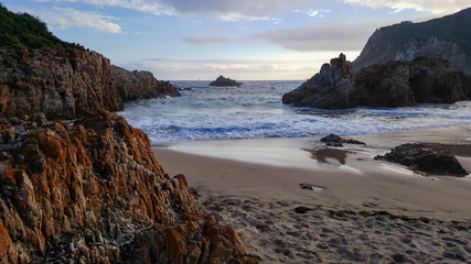 Fototapeta na wymiar Knysna heads taken from beach with rocks in foreground