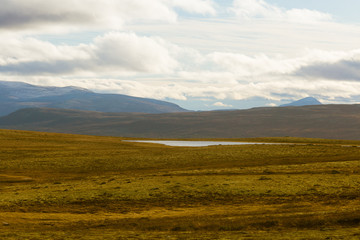 Fototapeta premium A beautiful mountain landscape with a lake in the distance. Autumn mountains in Norway. Fall scenery in Scandinavia.