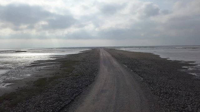 Aerial of Low tide path to the island Mand&oslash; in Denmark, only access by car &ndash; 4K