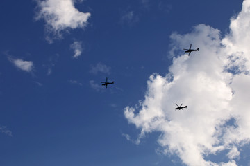 helicopters flying in sky with clouds