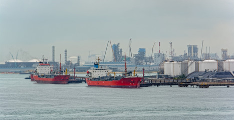 Fototapeta premium Tanker in front of an oil refinery plant