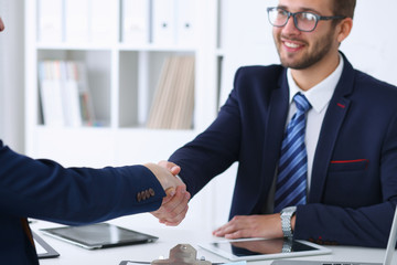 Business handshake at meeting or negotiation in the office. Partners are satisfied because signing contract or financial papers