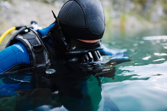 Male diver in wetsuit checking equipments before immerse